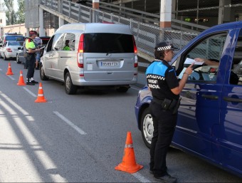 Una vigilant de Vilobí , en primer terme, i més al fons, un Mosso, demanant els papers a diversos taxis en el control d'ahir J. SABATER