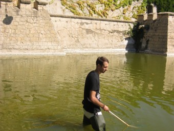 Un dels voluntaris mirant de retirar les tortugues del llac. ARXIU