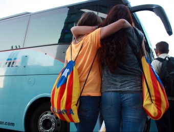 Dues persones es disposen a pujar a un dels autobusos que ha sortit des de València aquest dijous al matí per assistir a la Diada ACN