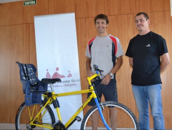 Jordi Arteman i Eduard Granados amb una de les bicis que han cedit als serveis socials del Pla de l'Estany. EL PUNT AVUI