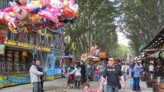 Un venedor de globus acoloreix l'entrada de la atraccions de la Devesa mentre les famílies passegen durant la diada de Sant Narcís D.V