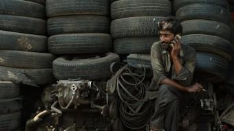 Un treballador parla pel seu Iphone en un dipòsit de ferralla de Mumbai PUNIT PARANJPE/AFP