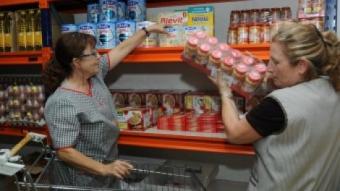 Unes voluntàries d'El Xiprer a l'espai del magatzem on guarden els aliments específics per a nadons RAMON FERRANDIS / EL 9 NOU