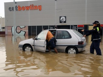 Un veí mirant de treure el cotxe del carrer inundat davant dels cinemes de Figueres.  MANEL LLADÓ