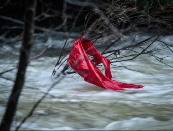 Els equips de rescat van localitzar ahir una jaqueta vermella enganxada a unes branques que podria ser de la jove desapareguda