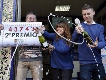 Els responsables d'una administració de loteria de València celebrant la venda del segon premi JUAN CARLOS CÁRDENAS / EFE