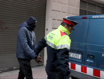 Un agent dels mossos traslladant a una furgoneta policial un dels detinguts en el dispositiu contra la banda dels Lobos callejeros ACN