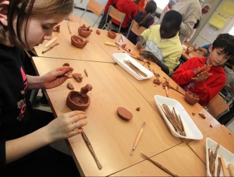 Una nena de tercer de curs de l'escola Els Estanys de Sils, fent una figura amb fang, dilluns. Al fons, companys seus, elaborant una escultura de Josep Martí-Sabé JOAN SABATER