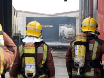 Dos bombers observen l'interior de la fàbrica on hi ha hagut la deflagració al polígon de les Comes ACN