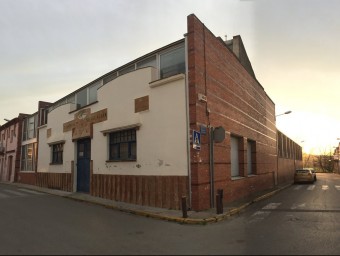 Façana de l'escola Madrenc . A la confluència entre els carrers Perelló, a l'esquerra de la imatge, i Escoles, a la dreta J.N