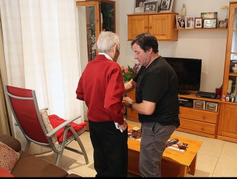Un cuidador atén un avi d'Arbúcies a casa seva, en una imatge d'arxiu MANEL LLADÓ