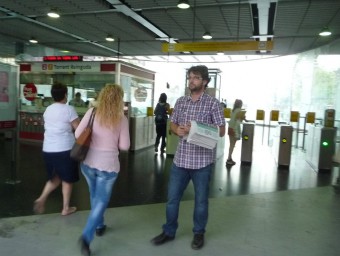 Un membre de Guanyant Torrent distribueix informació al Metro. ESCORCOLL