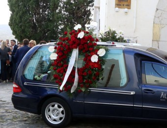 El cotxe fúnebre, aparcat fora l'església de Santa Maria de Cadaqués i la gent en sortir de la cerimònia MANEL LLADÓ