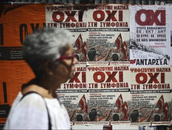 Una dona, passant per davant d'uns cartells que demanen el no en el referèndum de diumenge vinent, ahir, a Atenes EFE