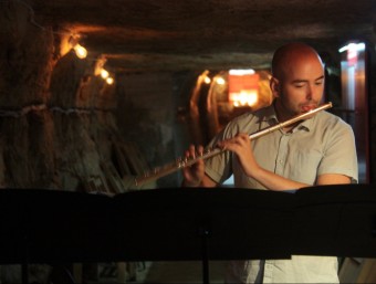 El flautista Sergi Gil va actuar al refugi antiaeri de Flix dilluns. LAIA POBLADO/ ACN