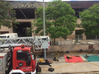 Els bombers vigilaven ahir a migdia que no revifés l'incendi que va cremar l'empresa Ris Fort R.M.B