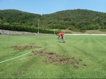 Lluís Graboleda preparant el reg del camp amb la zona afectada en primer terme, que ara s'haurà de reparar amb pans d'herba. J.C