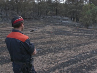 Un mosso d'esquadra observant la zona es va originar el foc, marcada pels investigadors ACN