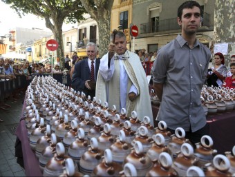 El mossèn beneïnt els càntirs de l'any. QUIM PUIG