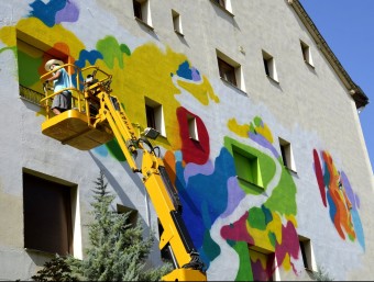 L'artista Sendra treballant en el mural “El camí de la Llibertat a la façana a l'hotel Pessets de Sort