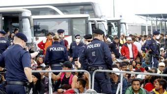 Centenars d'immigrants esperen a pujar a un autobús a Nickelsdorf, a Àustria REUTERS