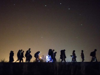Refugiats caminant de nit a la frontera entre Sèrbia i Hongria, a Roszke aquesta matinada EFE
