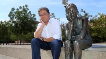 Enric Millor, cap de llista del PP, a la Plaça de la Constitució de Girona, imitant la pose de l'escultura de la nena que va néixer el mateix dia que es va aprovar la Carta Magna. MANEL LLADÓ