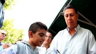 Xavier García Albiol signa un autògraf a Ahmed, un nen d'origen àrab que li ha demanat la firma fins a tres cops mentre el candidat passejava pel mercat de Cerdanyola, a Mataró ACN