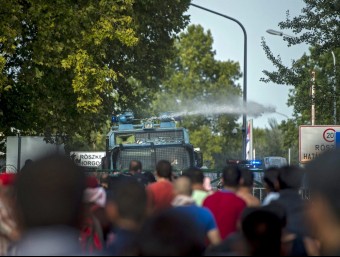 La policia hongaresa llança aigua a pressió contra els refugiats que intenten creuar la frontera des de Sèrbia, aquest dimecres al pas d'Horgos EFE