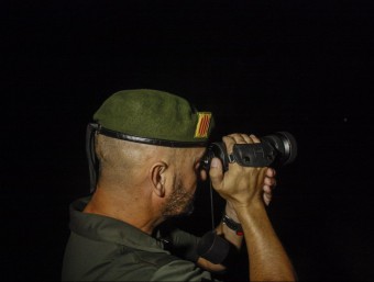 Un Agent Rural observant el perímetre del pantà amb un visor nocturn ACN