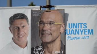 Dos cartells electorals dels candidats de Junts X Sí, Raül Romeva, i del PP, Xavier Garcia Albiol, se superposen en un fanal a Barcelona. AFP
