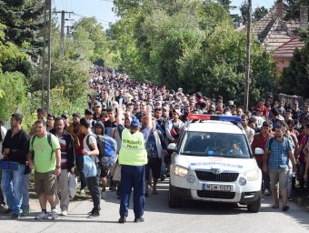 Un policia hongarès intenta dirigir una columna de desplaçats en ruta cap a Àustria, aquest dissabte a Hegyeshalom EFE