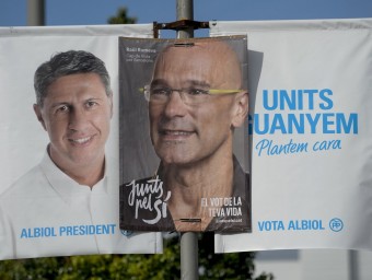 Dos cartells electorals dels candidats de Junts X Sí, Raül Romeva, i del PP, Xavier Garcia Albiol, se superposen en un fanal a Barcelona. AFP