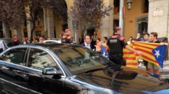 La policia limitant el pas dels ciutadans, i, al costat, la marxa del vehicle del president espanyol i el principal accionista de TV Girona, Joaquim Vidal, conversant amb els dirigents populars.. LLUÍS SERRAT / MARTÍ ARTALEJO
