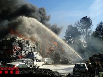 Efectius dels Bombers remullen una pila de vehicles incendiats, aquest dimarts a Sant Fruitós de Bages BOMBERS DE LA GENERALITAT