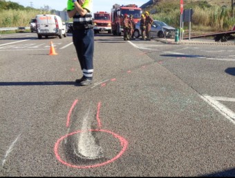 El cotxe accidentat, al fons de la imatge i els senyals a l'escenari de l'accident. ACN