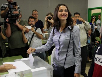 La cap de llista de C's, Inés Arrimadas, introdueix el sobre amb la papereta dins d'una urna d'un col·legi electoral del districte de les Corts, acompanyada dels seus nebots. Imatge del 27 de setembre de 2015 ACN