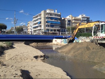 Les màquines treballen fa dies per buidar de sorra el calaix que havia quedat pràcticament taponat de sorra i obre al mar la desembocadura de la riera. E. FERRAN