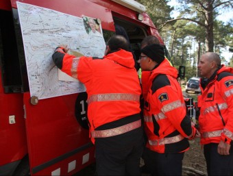 Els equips de rescat al camp base mirant el mapa de la zona on busquen el boletaire. LOURDES CASADEMONT/ ACN