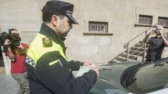 El cap de la Policia Local posa una multa a un dels cotxes de la Guàrdia Civil estacionat davant el consistori, aquest dimecres a Olot EFE