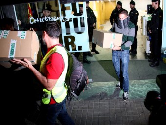 Agents de la Guàrdia Civil surten de la seu de CDC a Barcelona amb diveres caixes de cartró, aquest dimecres a la nit ACN