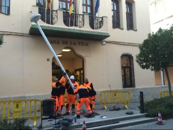 Els tècnics municipals retiren el fanal instal·lat des del 2010 al bell mig de la porta de l'edifici consistorial de Malgrat AJ. MALGRAT DE MAR