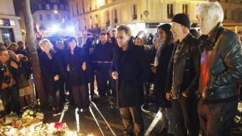 Bono, David Howell Evans i Adam Clayton, del grup U2, deixen flors en record de les víctimes dels atemptats de París, aquest dissabte a l'exterior de la sala Bataclan EFE