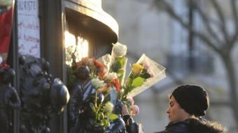 Un noi deixa una flor a la plaça de la República, a París, en homenatge a les víctimes dels atemptats de divendres REUTERS