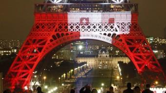 Policies vigilant davant la Torre Eiffel, il·luminada amb els colors de la bandera francesa, ahir reuters