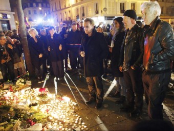 Bono, David Howell Evans i Adam Clayton, del grup U2, deixen flors en record de les víctimes dels atemptats de París, aquest dissabte a l'exterior de la sala Bataclan EFE