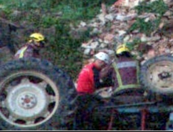 Els Bombers treballant en el lloc de l'accident amb el tractor bolcat OLOT TELEVISIÓ