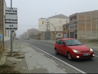 Un cartell recorda als conductors el nombre de veïns del poble que han mort atropellats a la travessia D.M