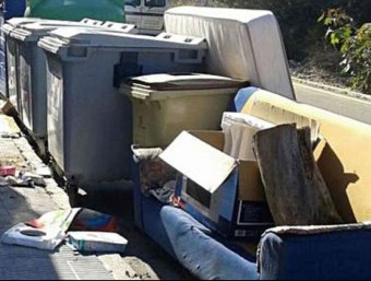 Un contenidor en un carrer de Cunit completament envoltat d'andròmines que haurien d'anar a la deixalleria.