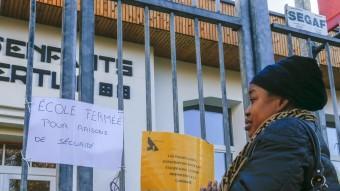 Un soldat a la Gran Place de Brussel·les, i una dona llegint el cartell d'una escola tancada per seguretat, ahir reuters